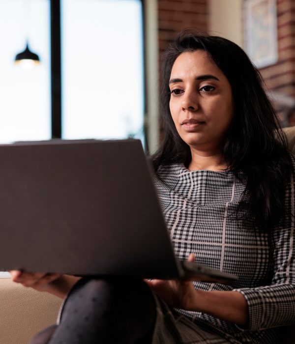 Indian person working on laptop at home